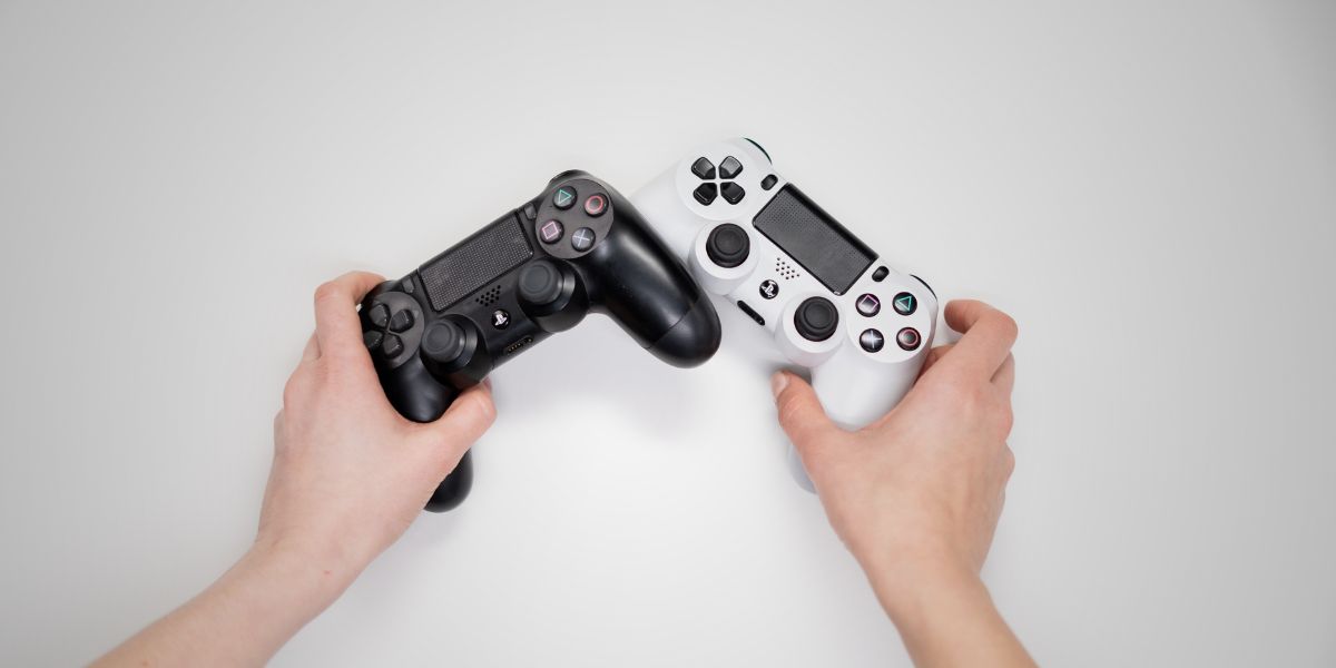 Person Holding Black and White Sony Ps 4 Controller