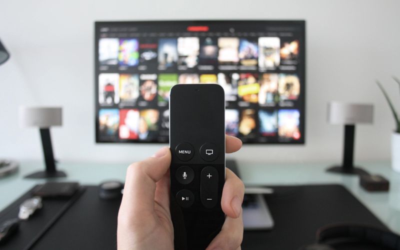 Man holding a remote in front of TV