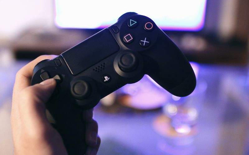 hand holding a black ps4 controller