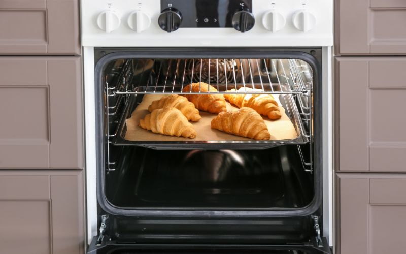 electric oven with croissants in kitchen