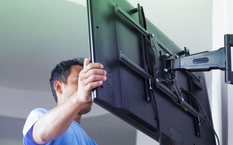man putting the TV on the wall