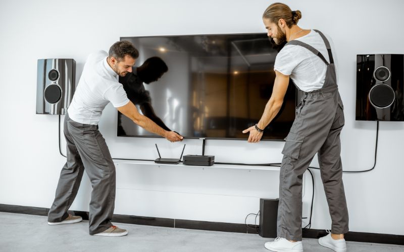 men installing TV at home